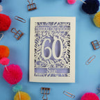 60th Birthday card with 'Happy Birthday 60 Sue' on a blue background with colourful pom-poms and paper clips.