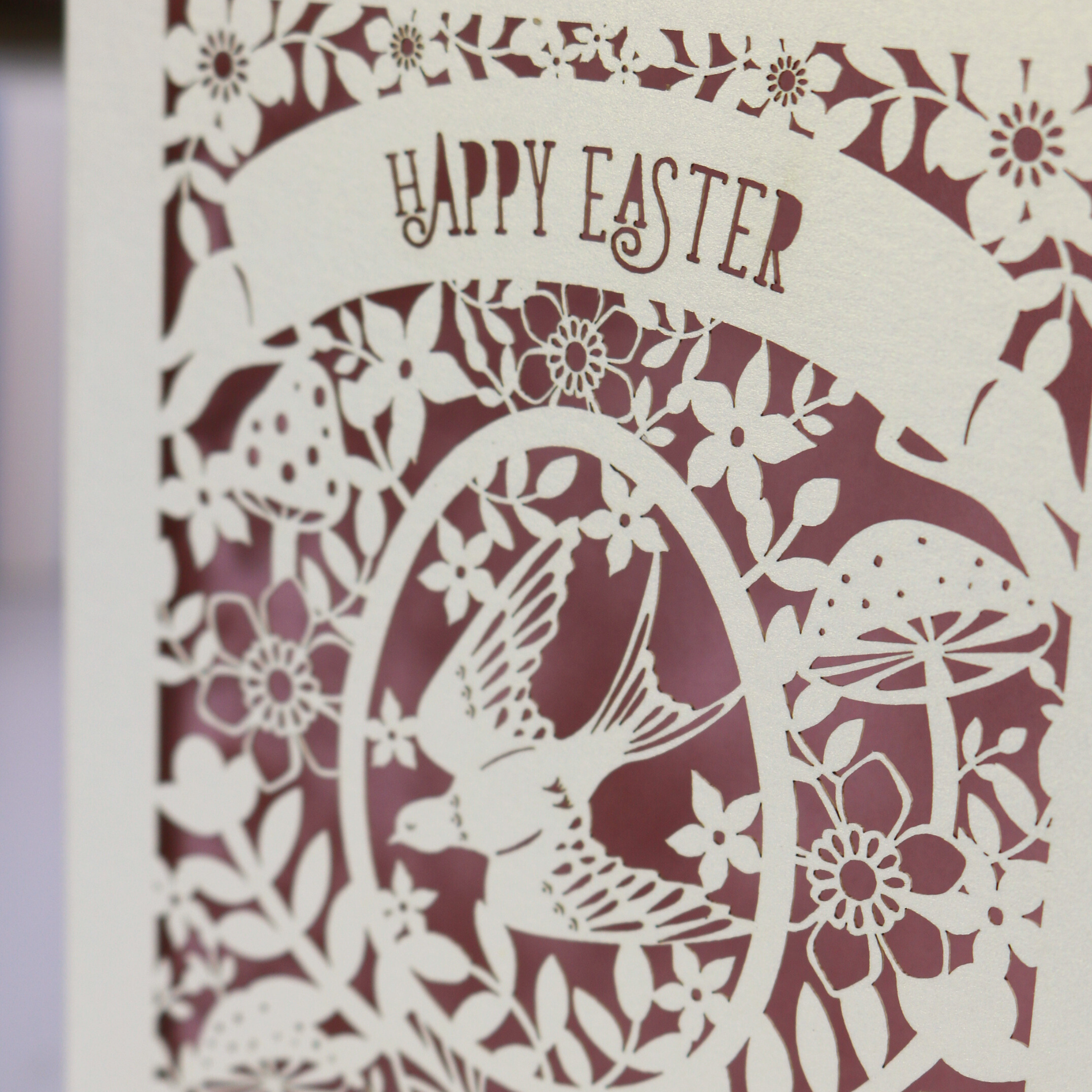 Decorative Easter card with cut-out design of a rabbit, flowers, and text 'Happy Easter'