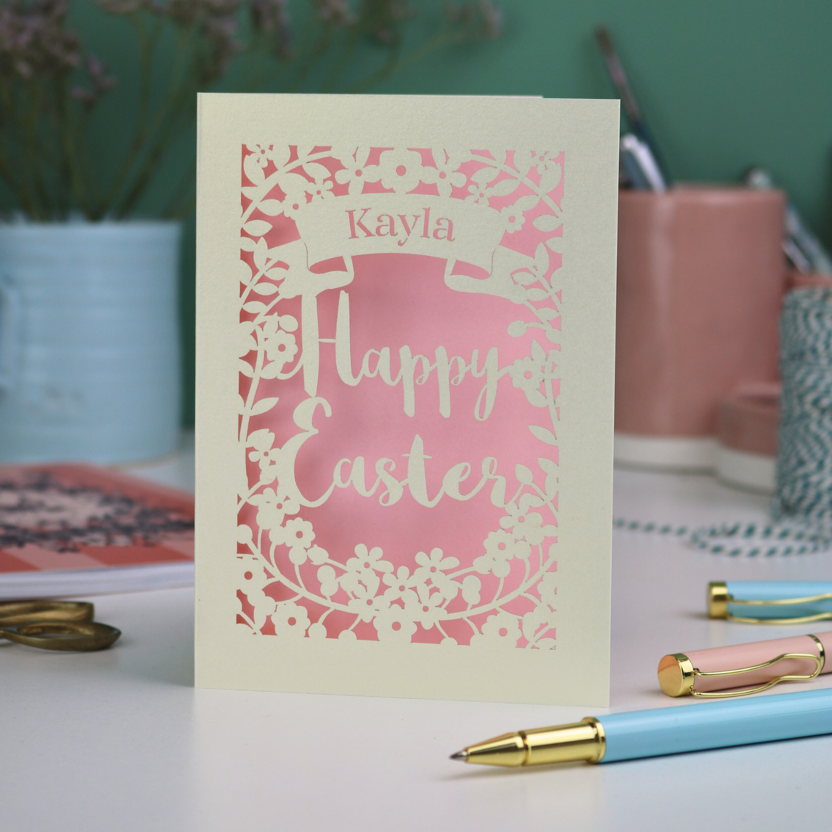 Laser-cut Easter card with 'Happy Easter' text on a desk with stationery 