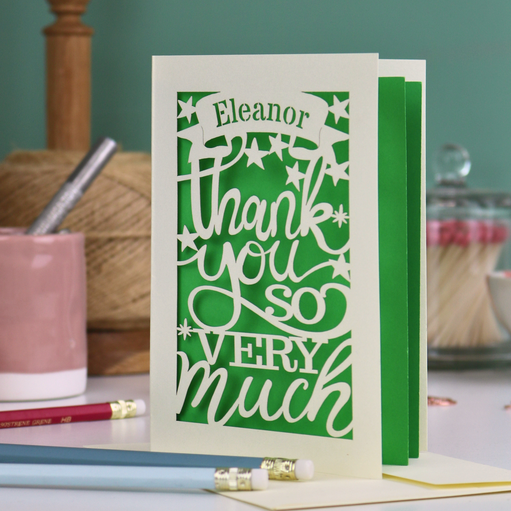 A cream laser cut thank you card with personalised name at the top in a banner, over text 'thank you so very much'