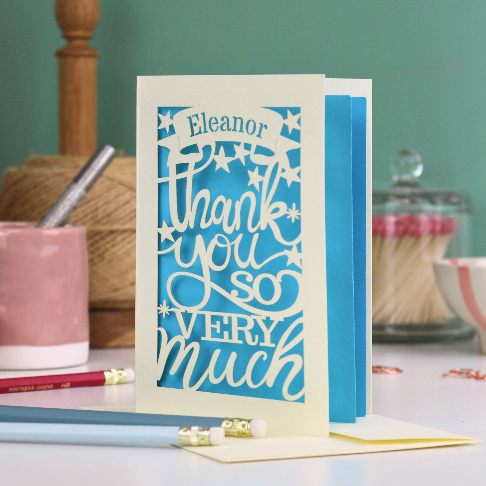 A cream laser cut thank you card with personalised name at the top in a banner, over text 'thank you so very much'