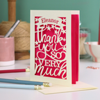 A cream laser cut thank you card with personalised name at the top in a banner, over text 'thank you so very much'