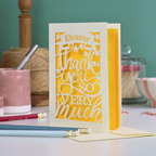 A cream laser cut thank you card with personalised name at the top in a banner, over text 'thank you so very much'