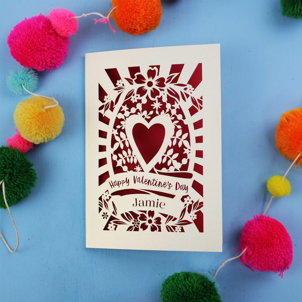Unique Valentine's card with floral heart design on a blue background with colourful pom-poms.