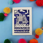 Decorative 1st Birthday card with ship design and 'CONNOR' text on a blue background with colourful pom-poms.