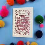 A personalised laser cut card that says "Becca, will you marry me?"