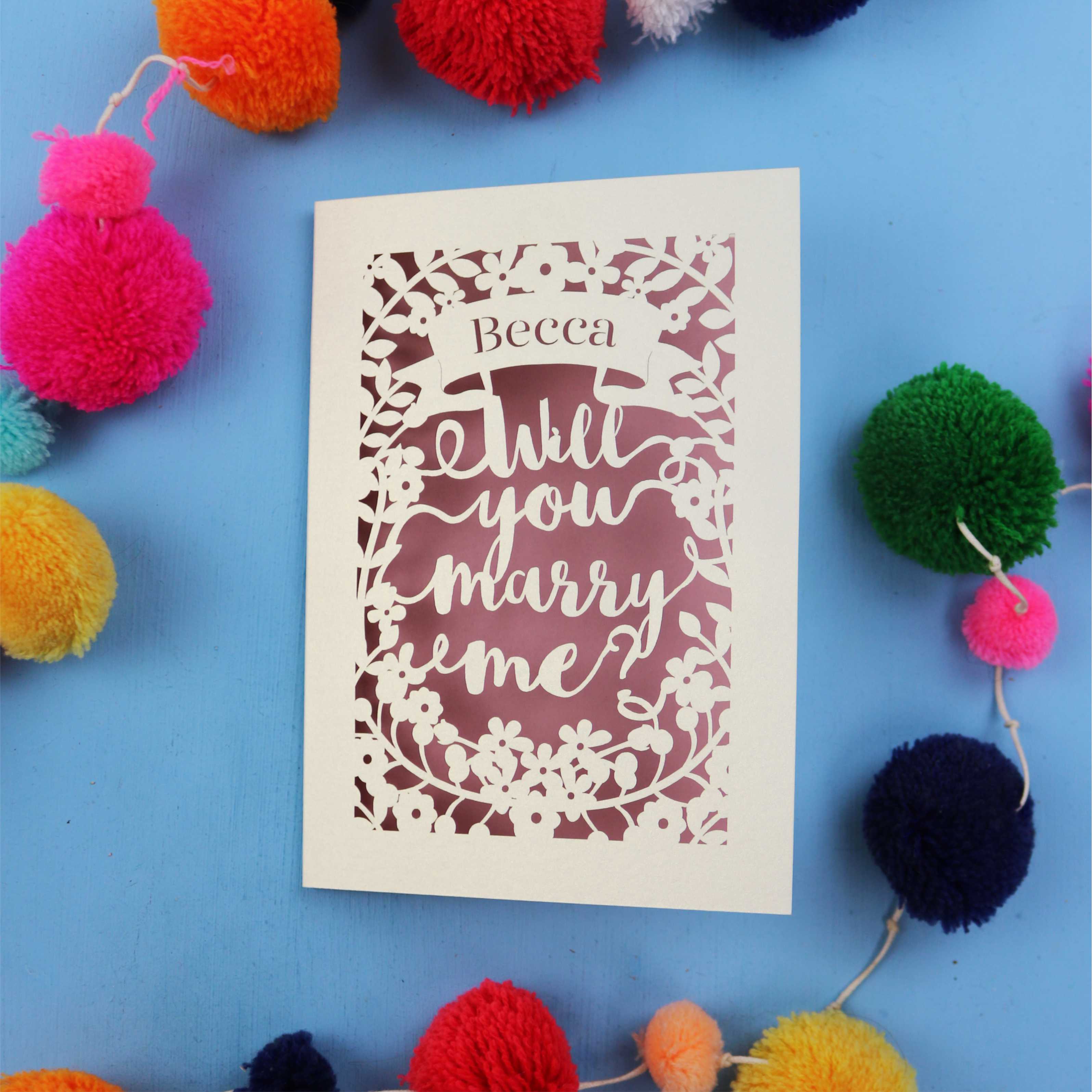 A personalised laser cut card that says "Becca, will you marry me?"