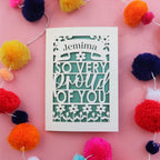 A laser cut congratulations card that is personalised with a name and reads "So very proud of you"