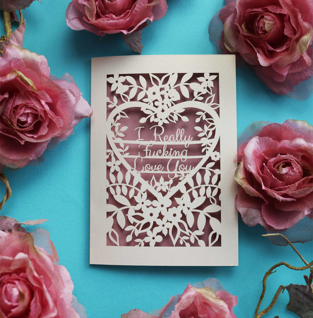A cut out Valentine's card that says "I really fucking love you" surrounded by flowers and leaves