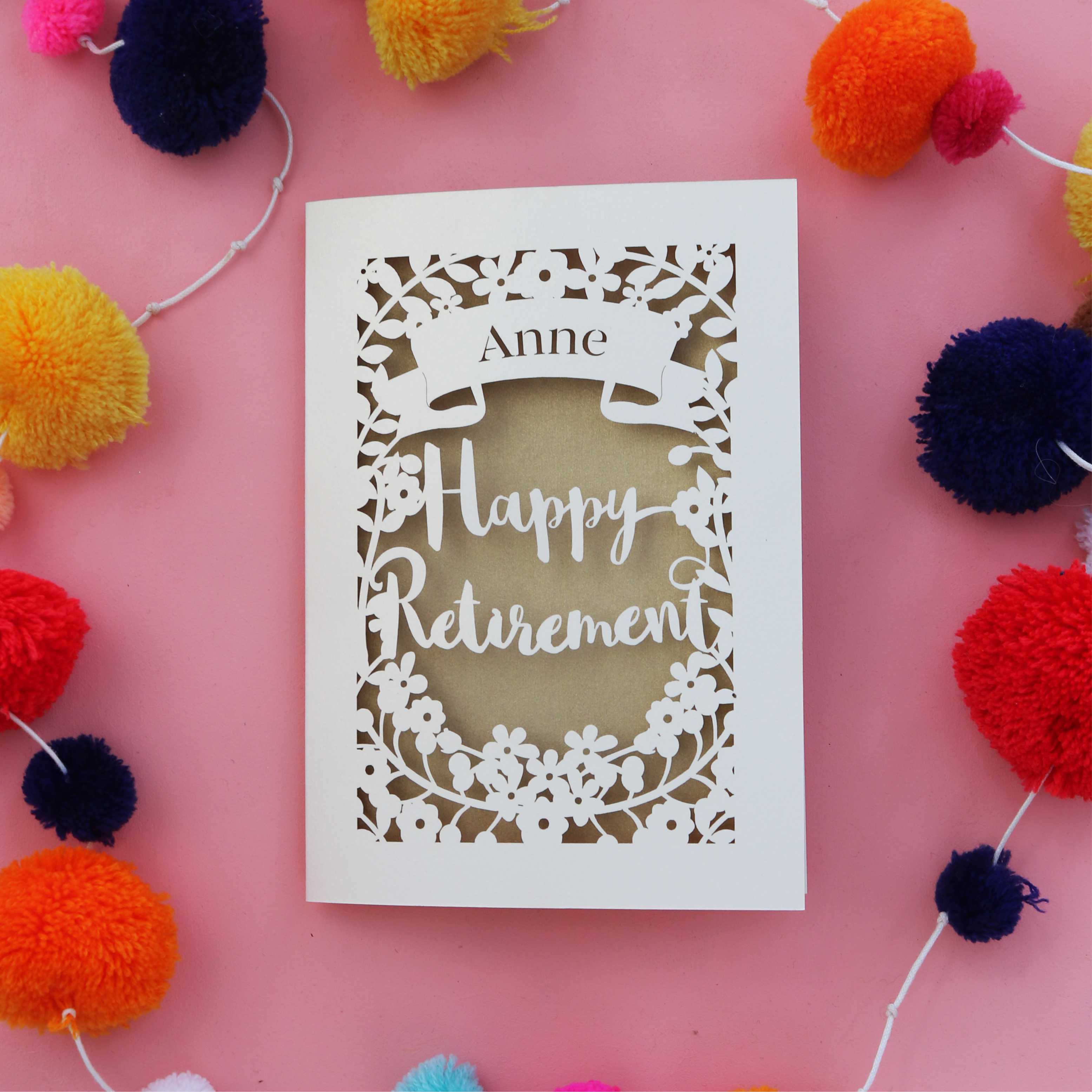 A cream laser cut retirement card with a gold paper insert. Card says "Name, happy retirement"