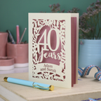 Papercut 40th anniversary Card with '40 Years' design on a desk with stationery items