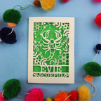 Decorative star sign birthday card with Scorpio symbol and 'EVIE' text on a blue background with colourful pom-poms.