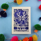 Decorative Scorpio birthday card with a scorpion star sign design and 'Evie Scorpio' text on a blue background with colourful pom-poms.