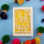 Decorative star sign birthday card with Scorpio symbol and 'EVIE' text on a blue background with colourful pom-poms.