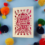 Sister Christmas card with 'Merry Christmas to my sister' text on a blue background with colourful pom-poms.