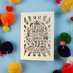 Sister Christmas card with 'Merry Christmas to my sister' text on a blue background with colourful pom-poms.