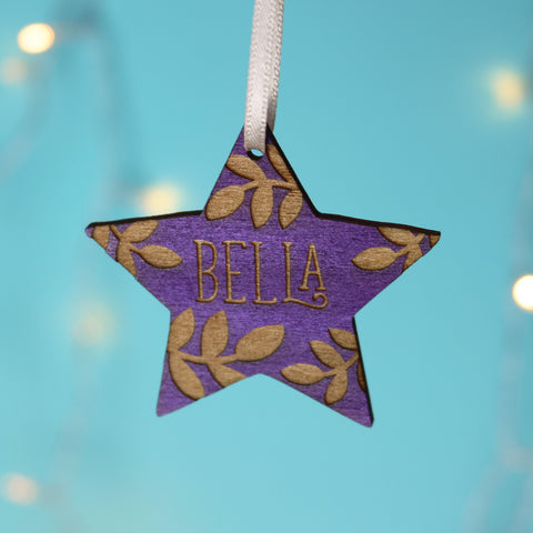 A personalised Christmas decoration in purple, engraved with a name.  - 