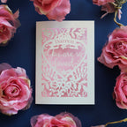 A paper cut Valentine's card personalised with a name. Card says "Name, you are so loved"