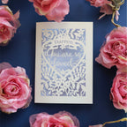 A paper cut valentines card - "You are so loved" is written inside a heart surrounded by flowers