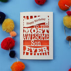 Son Birthday Card with 'Happy Birthday to the most awesome son ever' text on a blue background with colourful pom-poms.