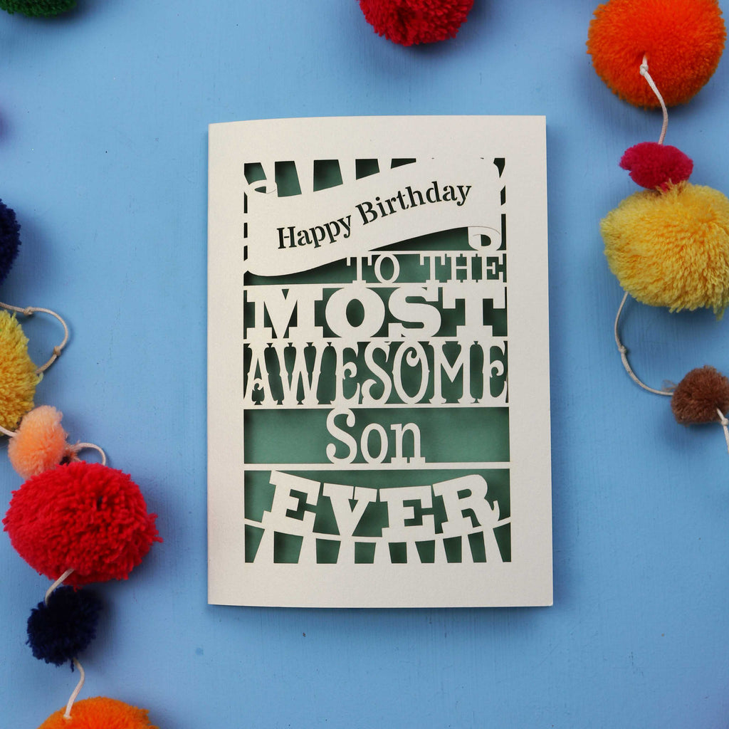 Laser cut Birthday Card with 'Happy Birthday to the most awesome son ever' text on a blue background with colourful pom-poms.