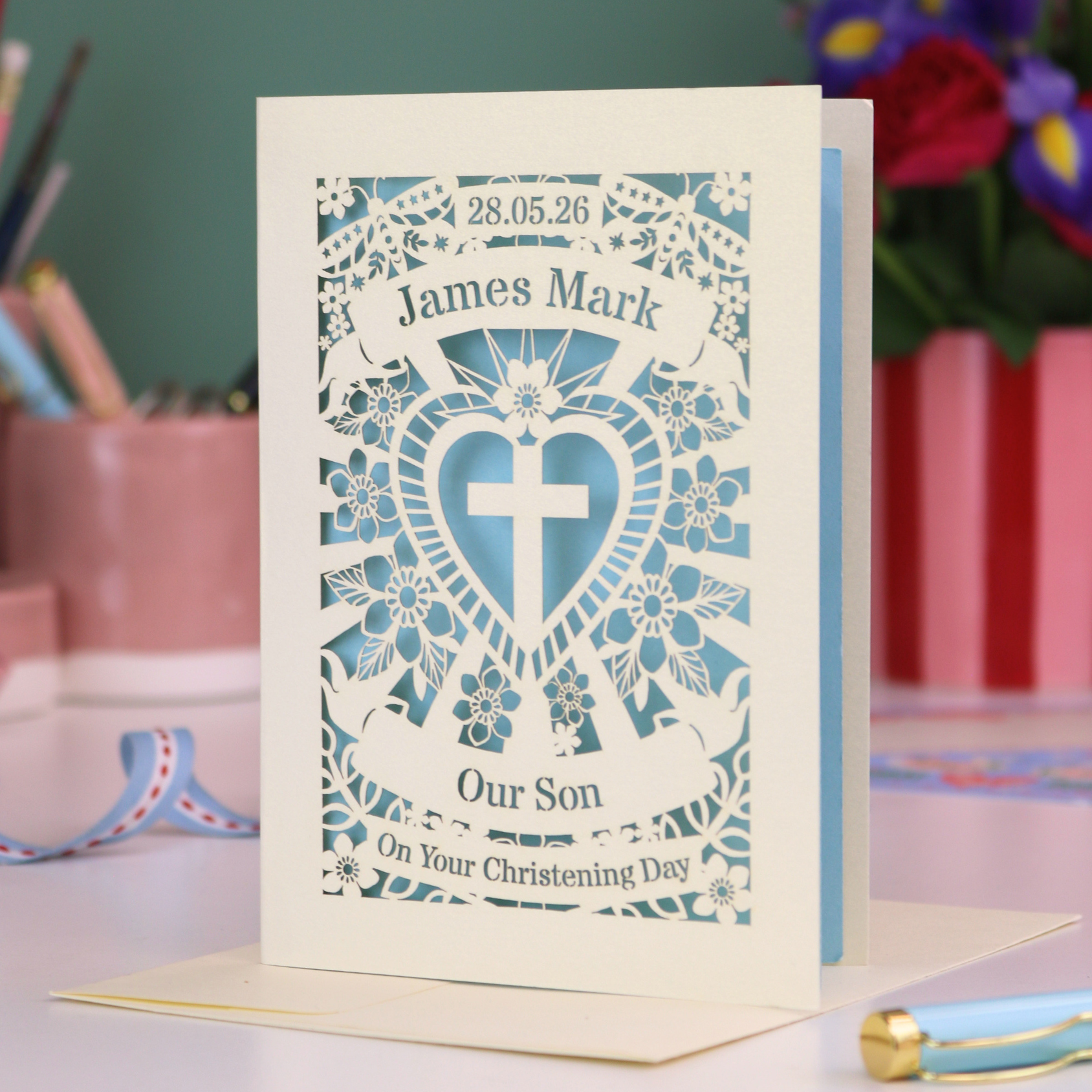 Personalized Son christening card with decorative design and text on a table.