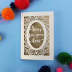 Luxury Sympathy Card with 'Sorry for your loss' text laser cut from cream card with a gold leaf paper backing, on a blue background.