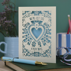 Decorative Step-mum Mother's Day card with floral design and text 'You're just like a mum to me' on a green surface with a pen and mug in the background.