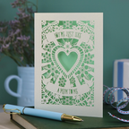 Decorative Step-mum Mother's Day card with floral design and text 'You're just like a mum to me' on a green surface with a pen and mug in the background.