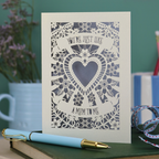 Decorative Step-mum Mother's Day card with floral design and text 'You're just like a mum to me' on a green surface with a pen and mug in the background.