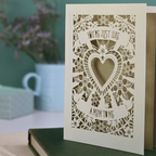 Decorative Step-mum Mother's Day card with floral design and text 'You're just like a mum to me' on a green surface with a pen and mug in the background.