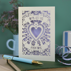 Decorative Step-mum Mother's Day card with floral design and text 'You're just like a mum to me' on a green surface with a pen and mug in the background.
