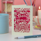 A paper cut Mother's Day Card that says "Here's to Strong Women, may we know them, may we be them, may we raise them"
