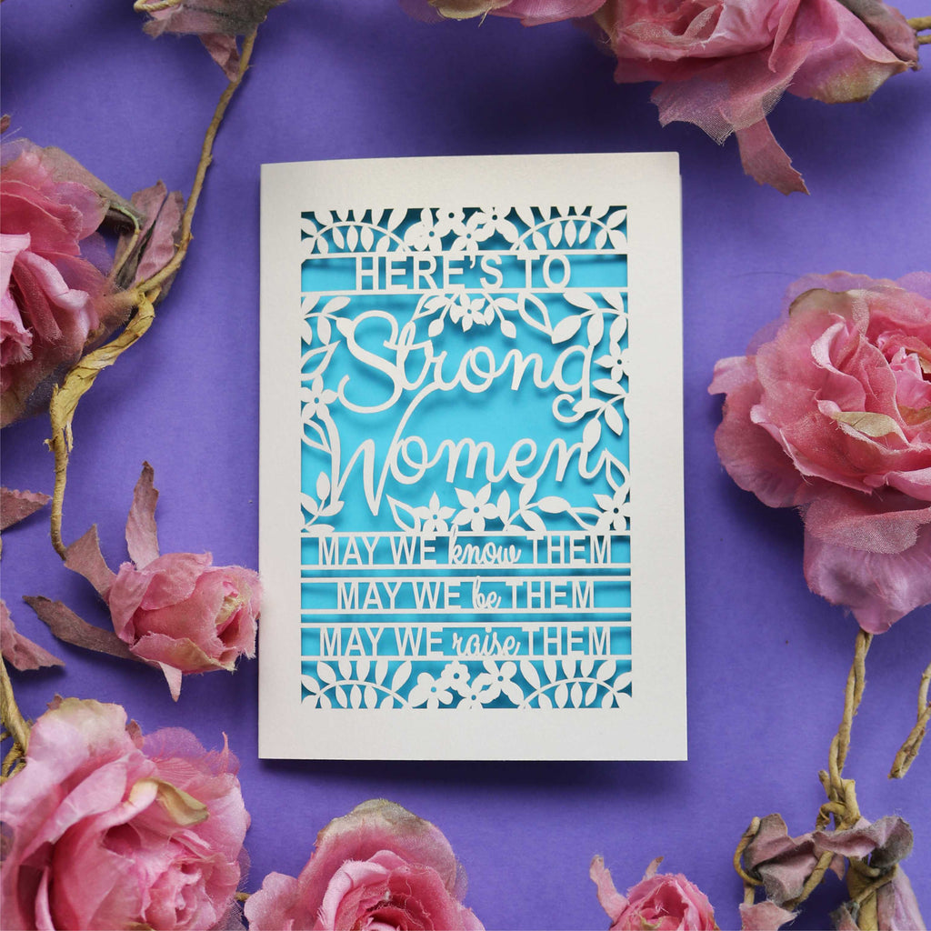 A paper cut Mother's Day Card that says "Here's to Strong Women, may we know them, may we be them, may we raise them"