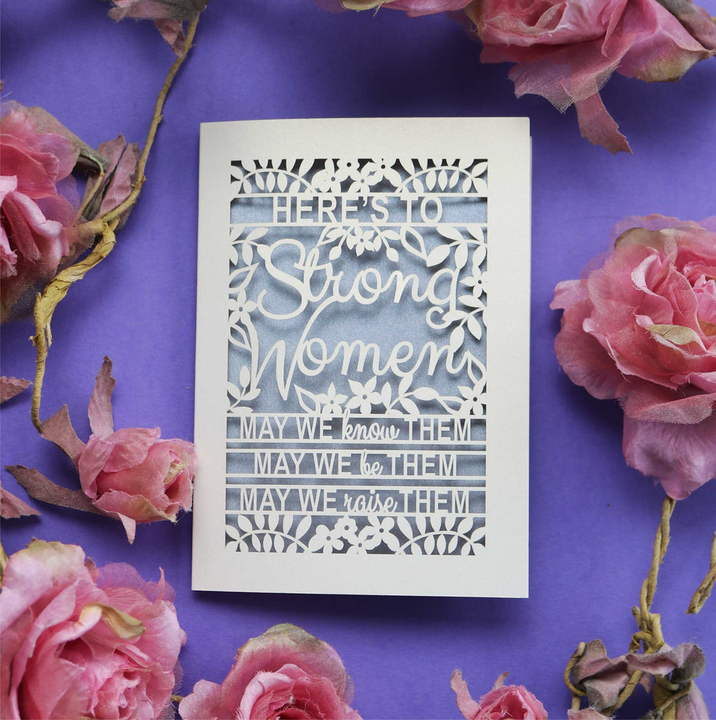 A laser cut Mother's Day Card that says "Here's to Strong Women, may we know them, may we be them, may we raise them"