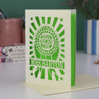 A laser cut thank you teacher card with rosette design and the words "Best teacher ever" in the centre of the rosette, personalised with the teacher's name underneath. Card is cream with a bright green paper insert