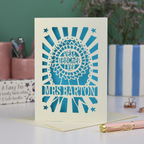 A laser cut thank you teacher card with rosette design and the words "Best teacher ever" in the centre of the rosette, personalised with the teacher's name underneath. Card is cream with a bright blue paper insert