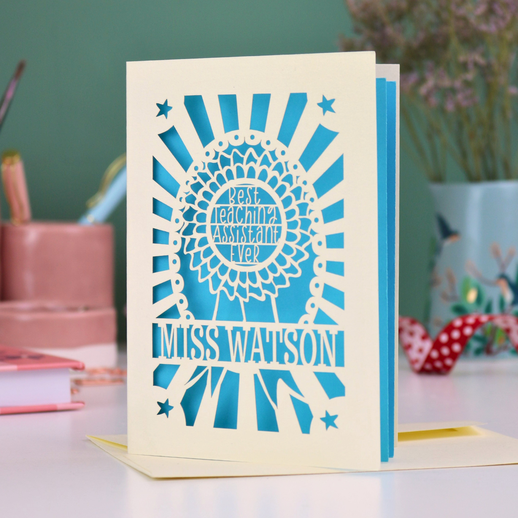 A special thank you teaching assistant card with cut out rosette design and text "Best Teaching Assistant Ever" and personalised with the name "Miss Watson"