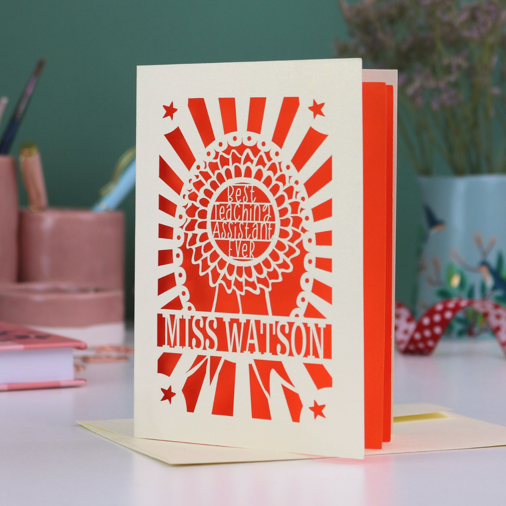 A laser cut thank you teachers assistant card with cut out rosette design and text "Best Teaching Assistant Ever" and personalised with the name "Miss Watson"
