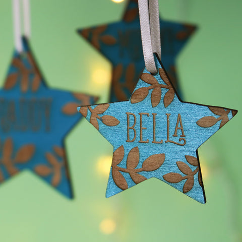 Personalised Christmas decorations, star shaped and pained teal with names engraved. - 