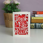 Cream thank you card with a bright red insert paper showing Thank you so very much and stars.