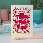 Personalised Laser-cut Thank you card with decorative elements on a table with stationery items.