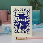 Personalised Laser cut card with 'Wendy Thank You' text on a white surface with decorative items.