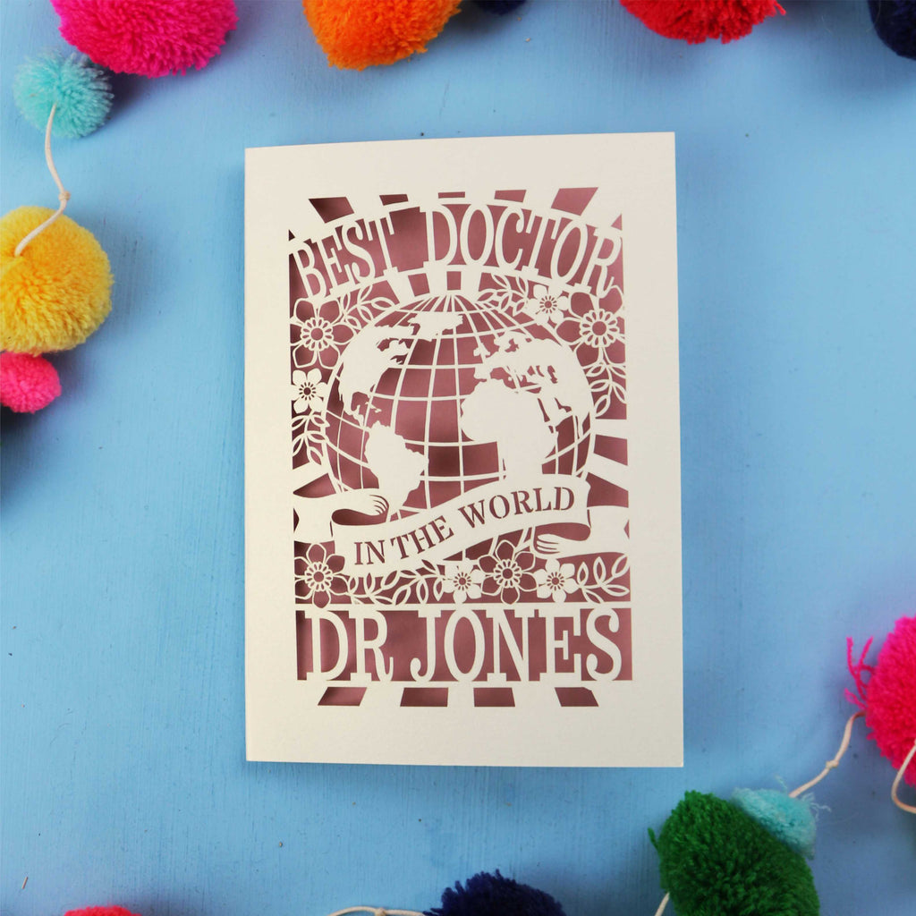 Personalised thank you Dr card with 'Best Doctor in the World' text on a blue background with colourful pom-poms.