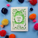 Personalised thank you teacher card with 'Thank You Mrs Benny' text surrounded by colourful pom-poms on a blue background