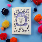 Personalised thank you card with 'Thank You Mrs Benny' text surrounded by colourful pom-poms on a blue background