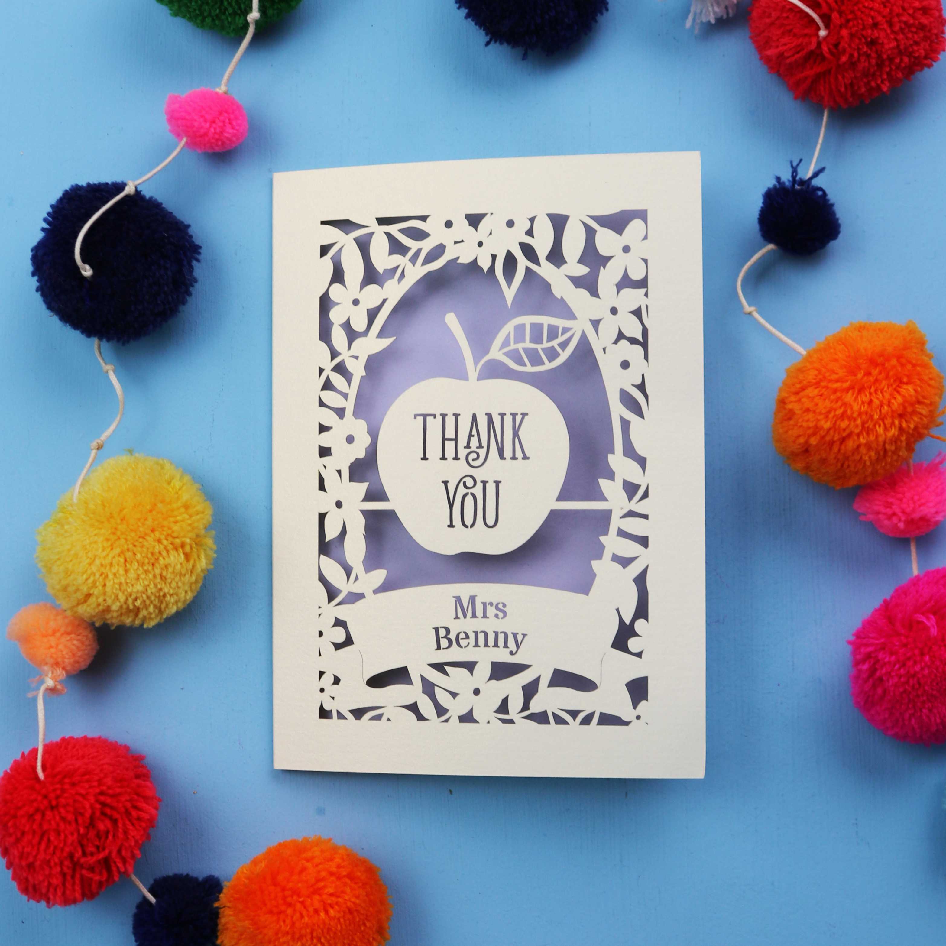 Personalised thank you card with 'Thank You Mrs Benny' text surrounded by colourful pom-poms on a blue background