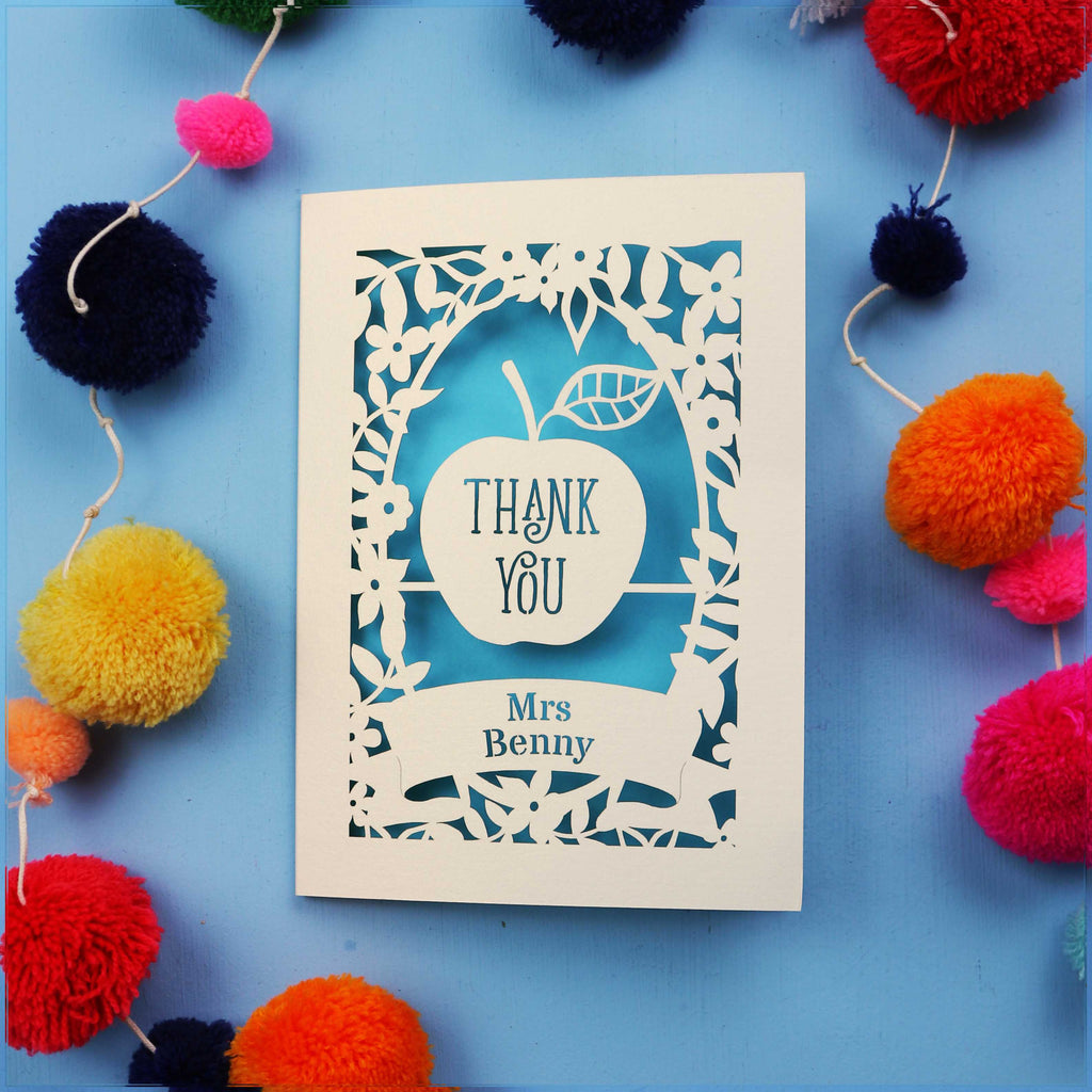 Personalised thank you teacher cards with 'Thank You Mrs Benny' text surrounded by colourful pom-poms on a blue background