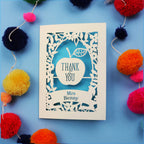 Personalised thank you teacher cards with 'Thank You Mrs Benny' text surrounded by colourful pom-poms on a blue background