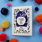 Personalised thank you teacher card with 'Thank You Mrs Benny' text surrounded by colourful pom-poms on a blue background